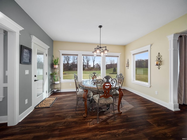 dining room featuring dark hardwood / wood-style flooring, a wealth of natural light, and a notable chandelier