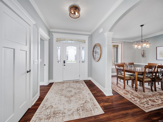 entrance foyer featuring dark wood-type flooring, ornate columns, and ornamental molding