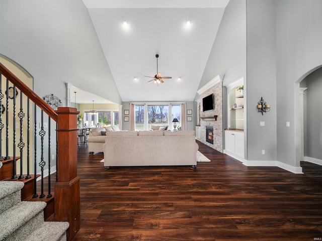 living room featuring a fireplace, dark wood-type flooring, and a high ceiling