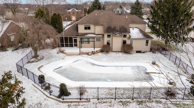 snow covered rear of property featuring a sunroom and a deck