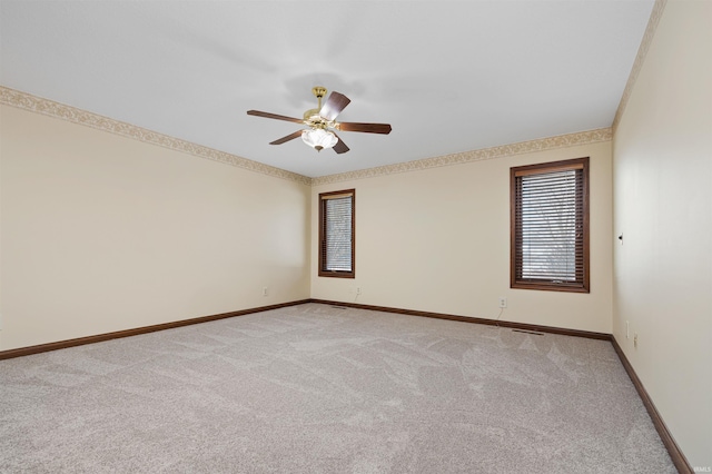 carpeted empty room featuring crown molding and ceiling fan