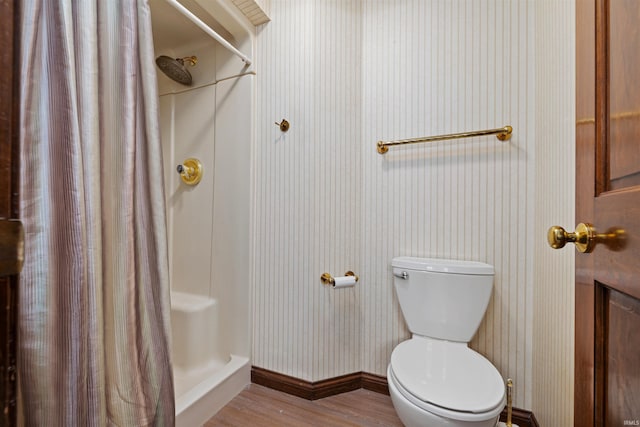 bathroom featuring hardwood / wood-style floors, curtained shower, and toilet