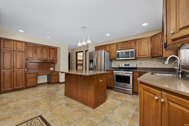 kitchen with a kitchen island, built in desk, decorative light fixtures, sink, and stainless steel appliances