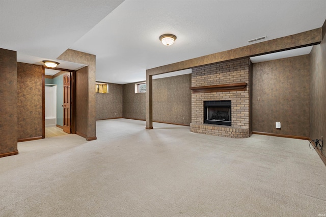 unfurnished living room with a fireplace, light carpet, and a textured ceiling