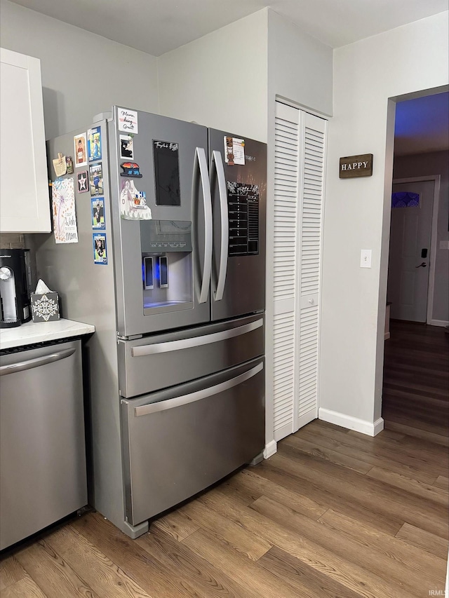 kitchen with light wood-type flooring, white cabinetry, and stainless steel appliances