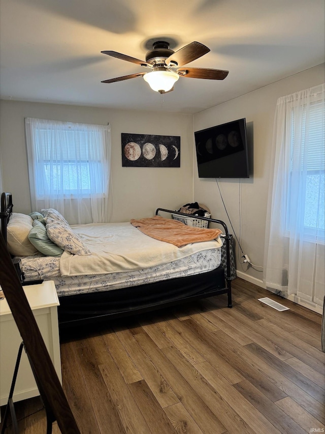 bedroom with ceiling fan and dark wood-type flooring