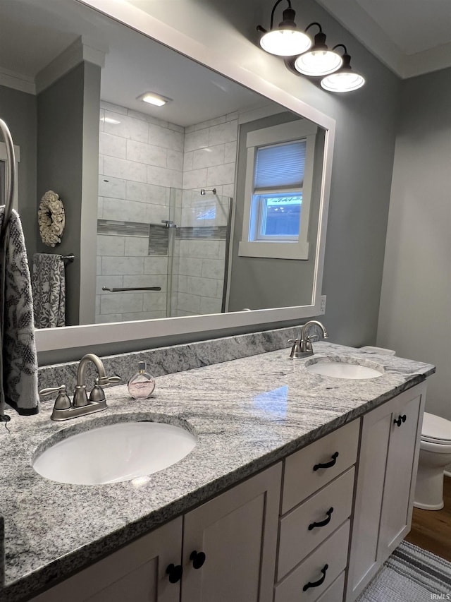 bathroom with ornamental molding, an enclosed shower, toilet, vanity, and hardwood / wood-style flooring