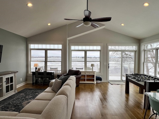 living room featuring vaulted ceiling, ceiling fan, and dark wood-type flooring