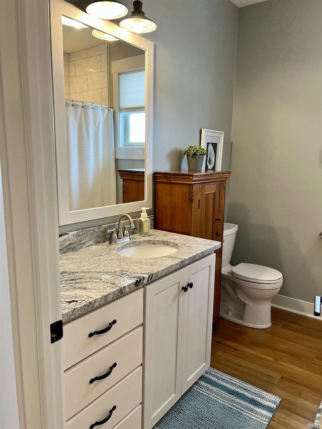 bathroom featuring vanity, hardwood / wood-style flooring, toilet, and walk in shower