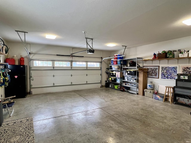 garage featuring black refrigerator and a garage door opener