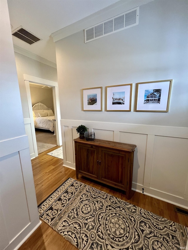 corridor with crown molding and light hardwood / wood-style flooring