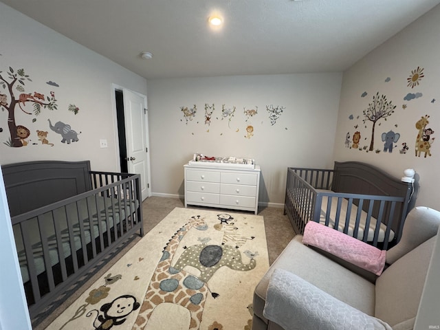 carpeted bedroom with a nursery area