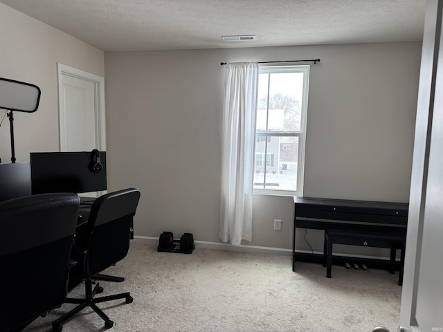 office area featuring light carpet and a textured ceiling