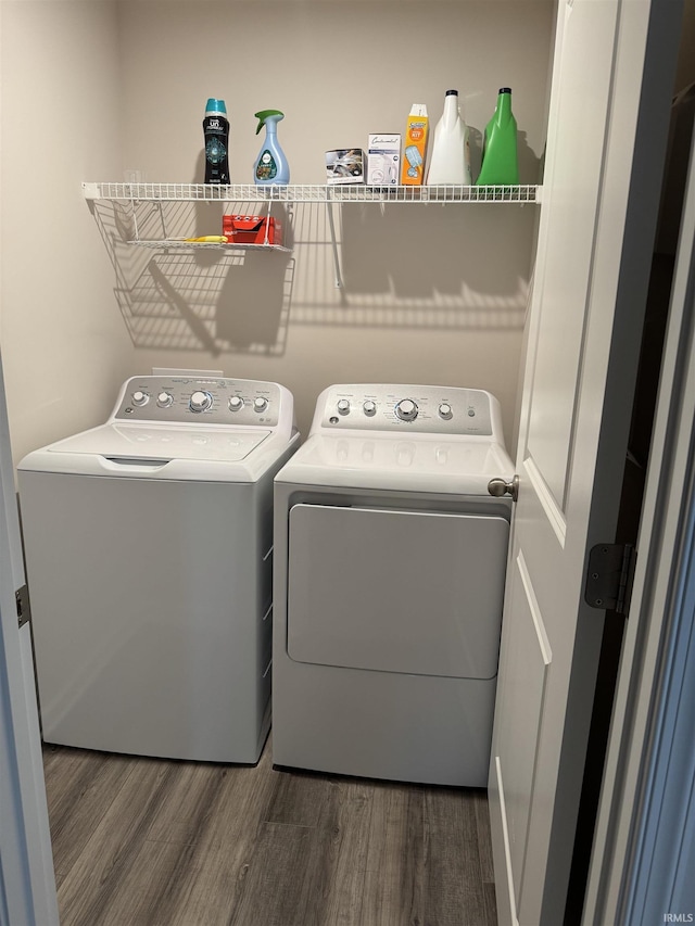 laundry area with dark hardwood / wood-style floors and washing machine and clothes dryer