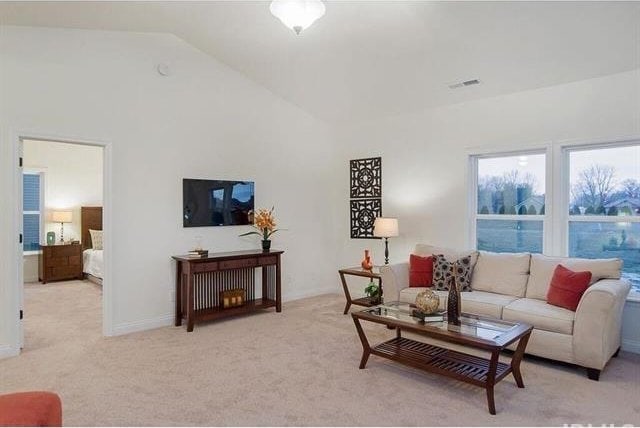 living room with light carpet and vaulted ceiling