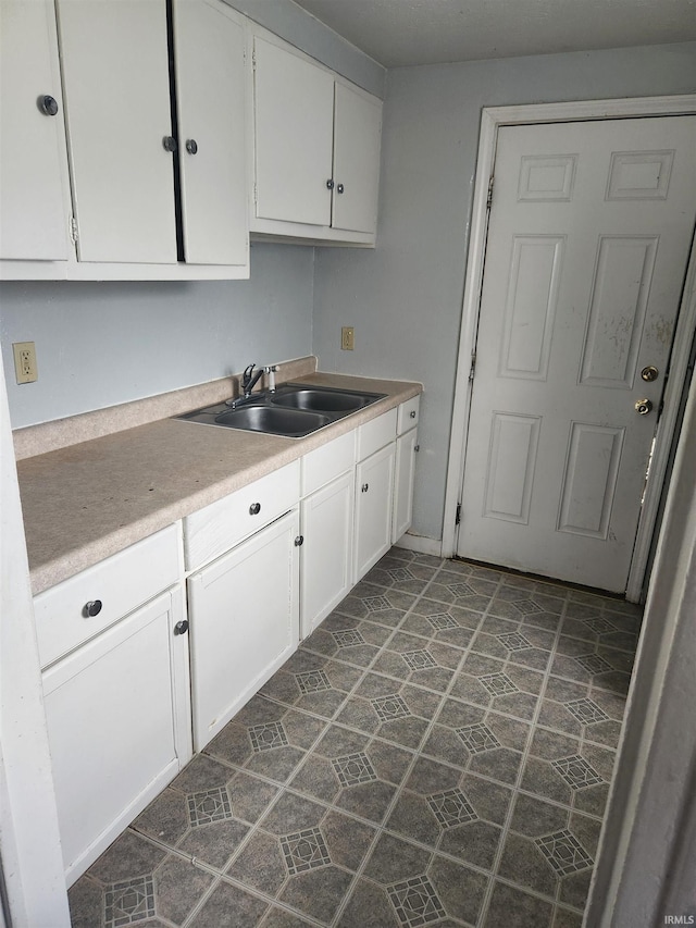 kitchen featuring white cabinets and sink