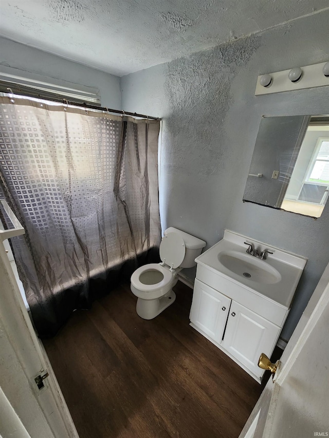 full bathroom featuring vanity, toilet, shower / bath combo with shower curtain, a textured ceiling, and wood-type flooring