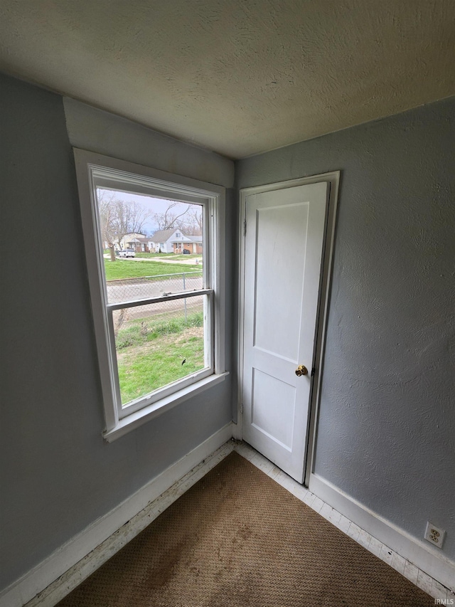 tiled empty room with a textured ceiling