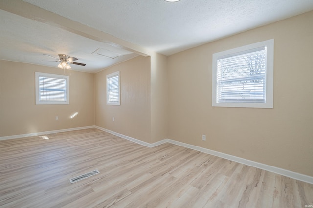 spare room with ceiling fan, a textured ceiling, and light wood-type flooring