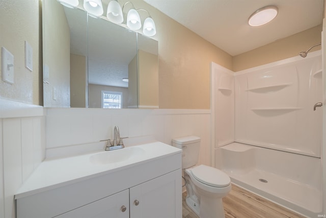 bathroom with a shower, hardwood / wood-style floors, a textured ceiling, toilet, and vanity