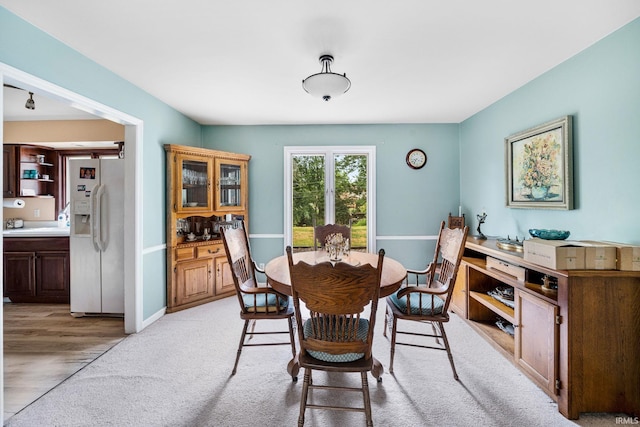 dining space featuring light carpet