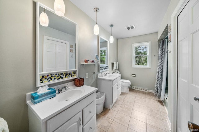 bathroom with toilet, vanity, and tile patterned floors