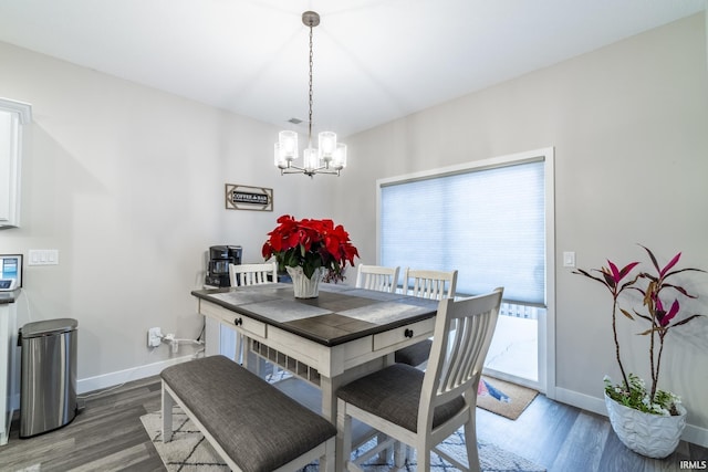 dining space featuring an inviting chandelier and dark wood-type flooring