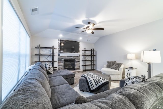 living room featuring ceiling fan, light colored carpet, a fireplace, and vaulted ceiling