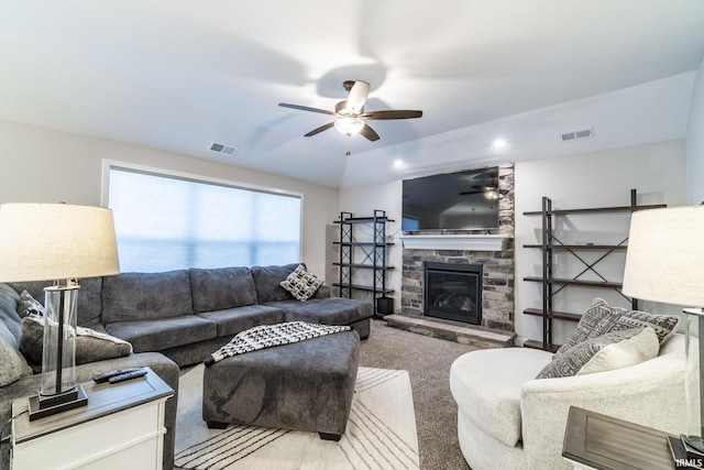 living room featuring a fireplace, carpet flooring, and ceiling fan