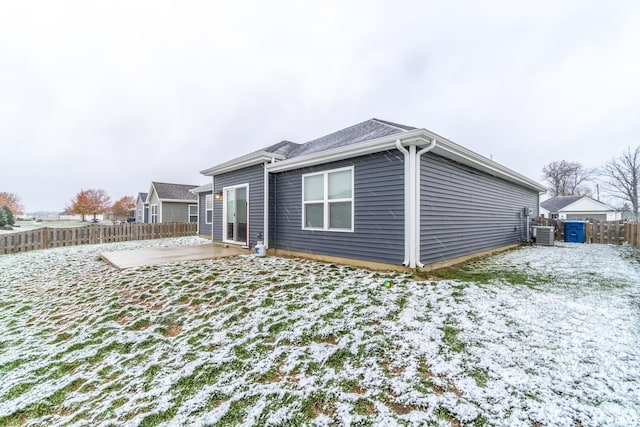 snow covered rear of property featuring a patio area and central air condition unit