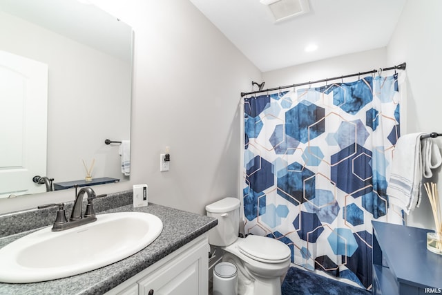 bathroom featuring vanity, toilet, and walk in shower