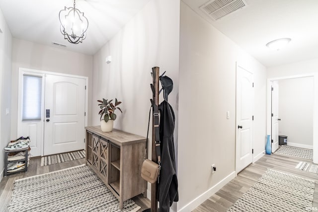 entryway with light hardwood / wood-style flooring and a chandelier