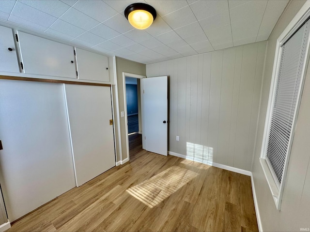 unfurnished bedroom featuring light hardwood / wood-style floors and a closet