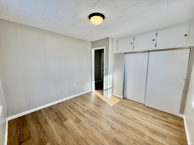 unfurnished bedroom with light hardwood / wood-style floors and a closet