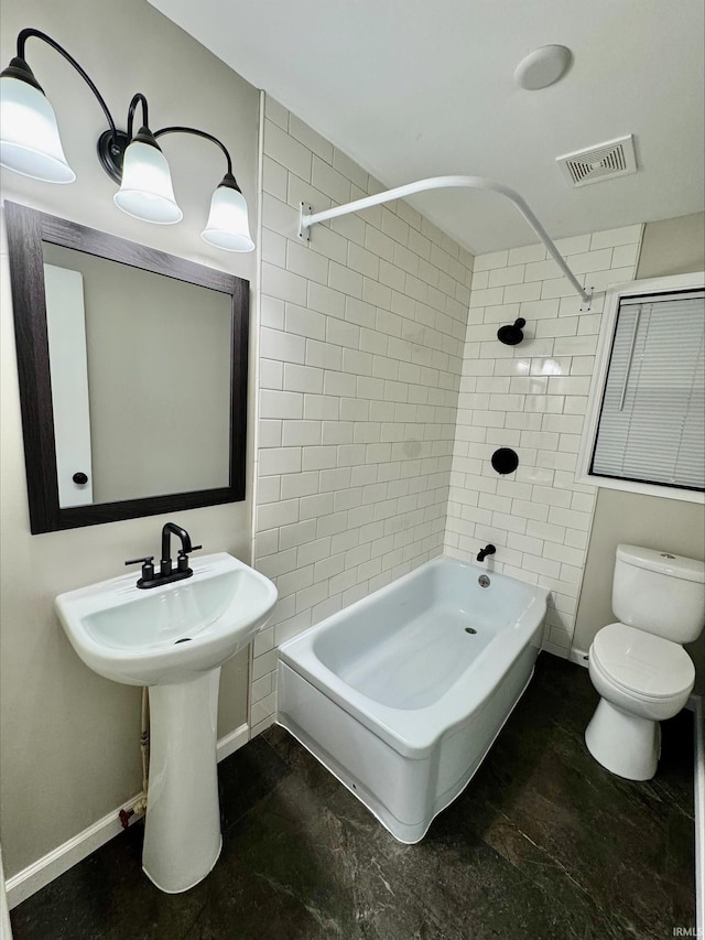 bathroom with toilet and tiled shower / bath