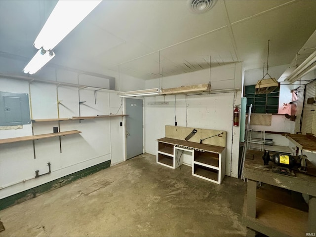 basement featuring electric panel and a workshop area