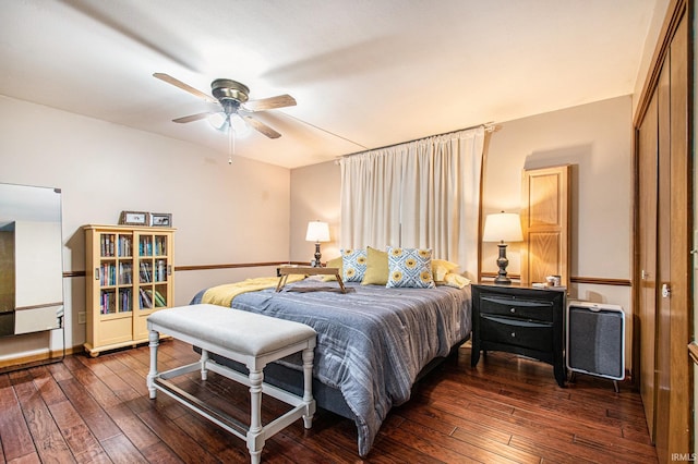 bedroom with a closet, dark hardwood / wood-style floors, and ceiling fan