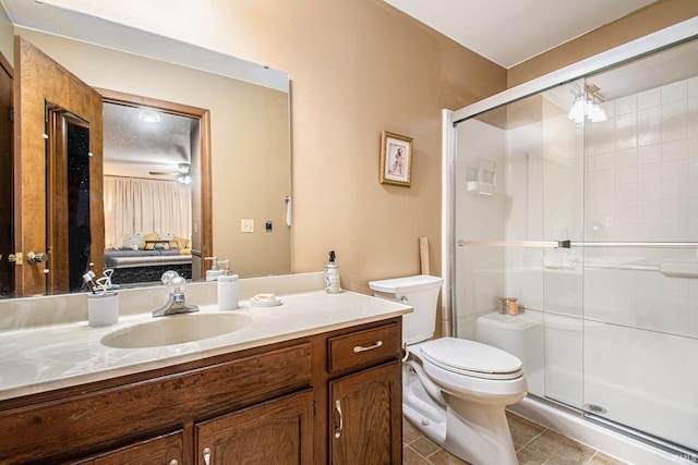 bathroom featuring walk in shower, vanity, ceiling fan, tile patterned flooring, and toilet