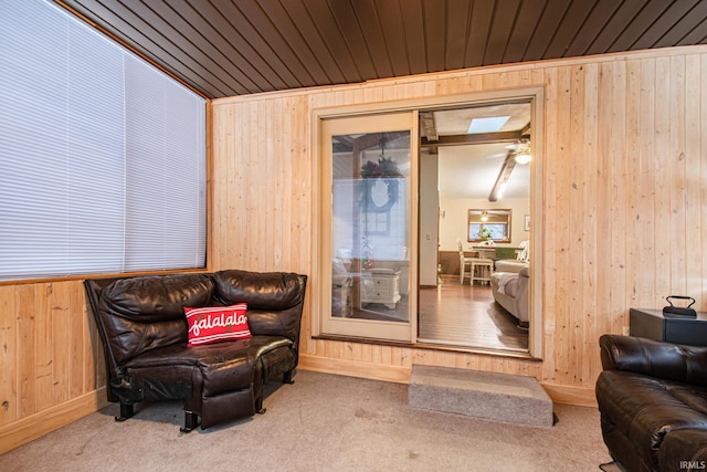 living area with wooden walls, carpet floors, and wood ceiling