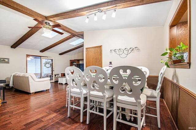 dining space with vaulted ceiling with beams, dark hardwood / wood-style floors, ceiling fan, and wooden walls