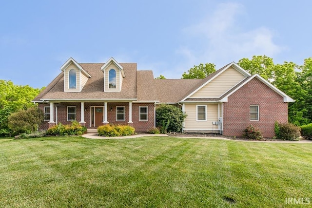 new england style home featuring a front lawn and a porch