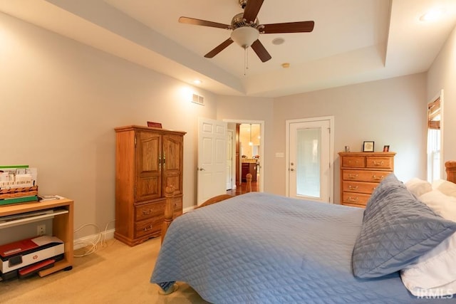 bedroom featuring a tray ceiling, ceiling fan, and light colored carpet