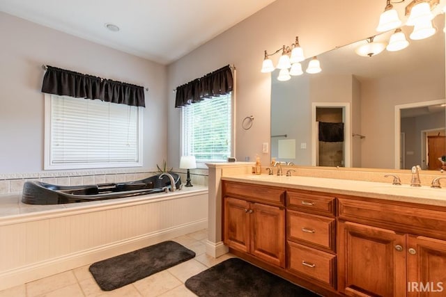 bathroom with tile patterned floors, a washtub, and vanity