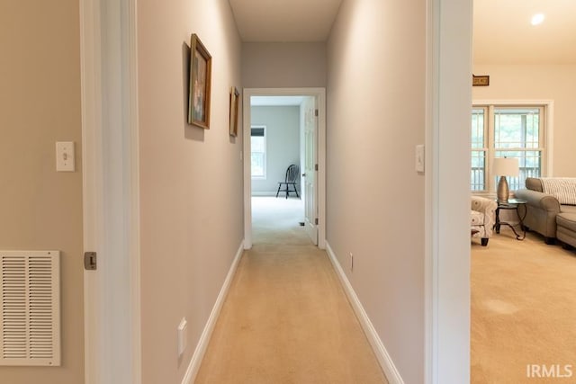 hallway featuring light colored carpet