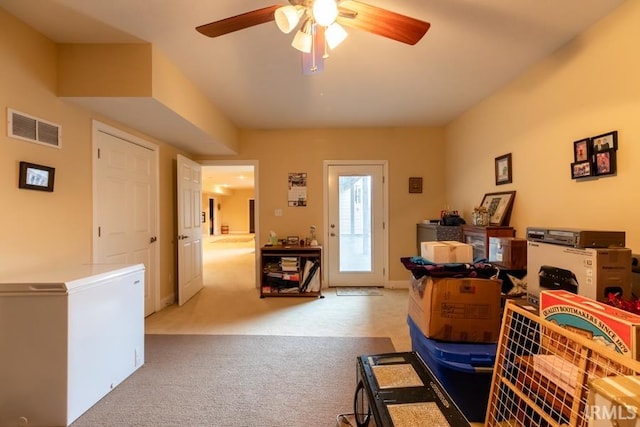 interior space with ceiling fan and light carpet