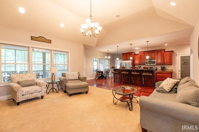 living room with vaulted ceiling, a wealth of natural light, and a chandelier