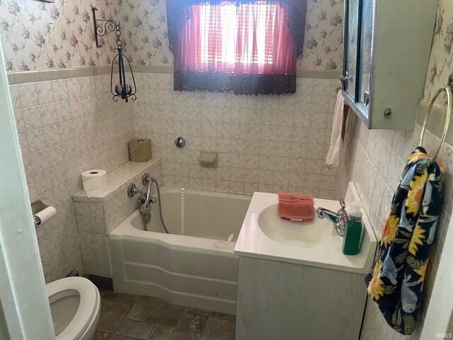 bathroom with a bathing tub, toilet, sink, and tile walls