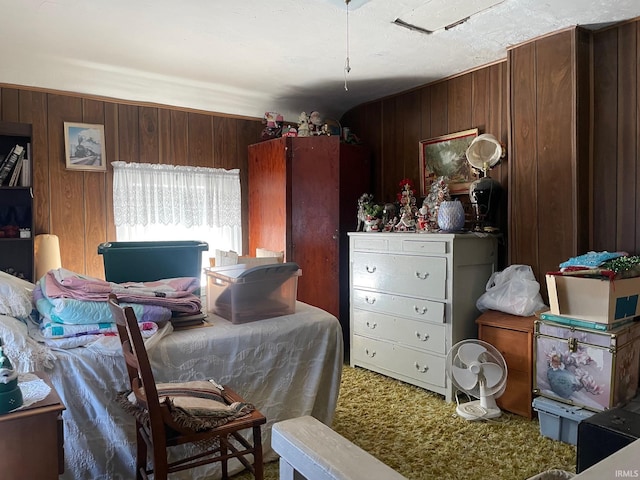 bedroom with carpet flooring and wood walls