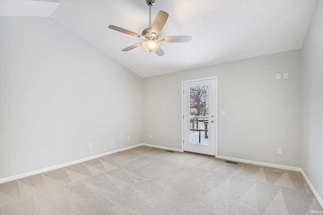 spare room featuring light carpet, ceiling fan, and vaulted ceiling