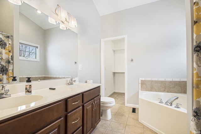 bathroom with tile patterned flooring, vanity, a tub to relax in, and toilet